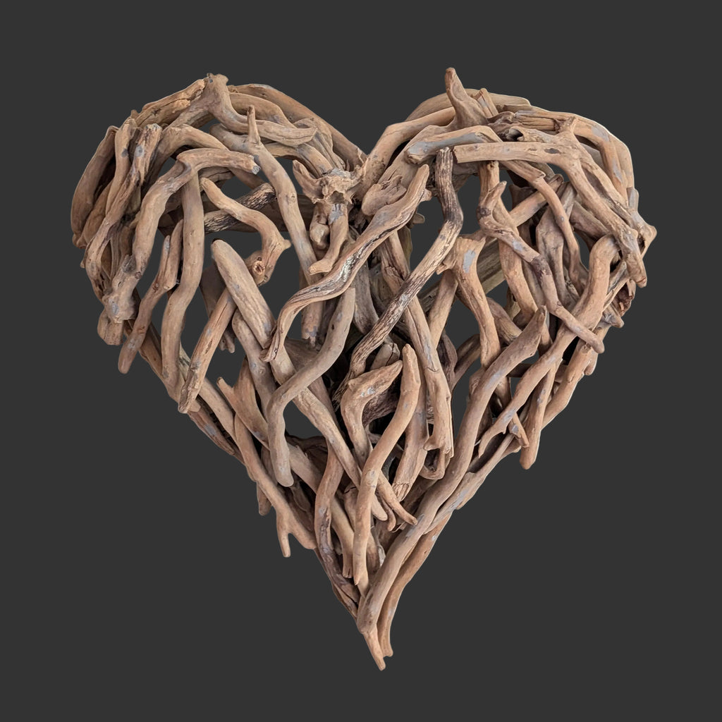 Heart-shaped wall art made of driftwood on a white background