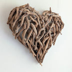 Heart-shaped wall art made of driftwood on a white background