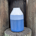 Decorative vase with blue and white pattern on a wooden post