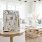 Framed beach scene with a house on a hill, inside a distressed white frame.
